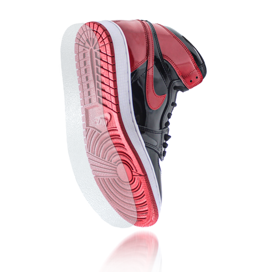 A black and red high-top sneaker is shown from the side and bottom on a white background with reflection, featuring the Sole Guard Jordan 1 Traction Sole Guard 3 Pack for enhanced sneaker protection.