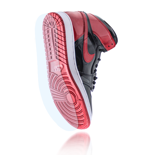 A black and red Jordan 1 Nike sneaker is shown from a low angle, highlighting the sole and side details protected by the Jordan 1 Sole Guard.