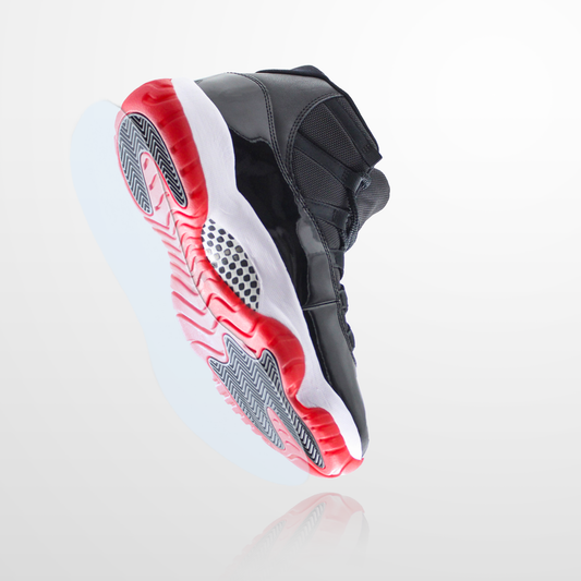 Black and red Jordan 11s basketball shoe with a white midsole, shown from a low angle to highlight the sole—ideal for showing off your sneaker preservation or adding the Jordan 11 Sole Guard to keep them looking fresh.