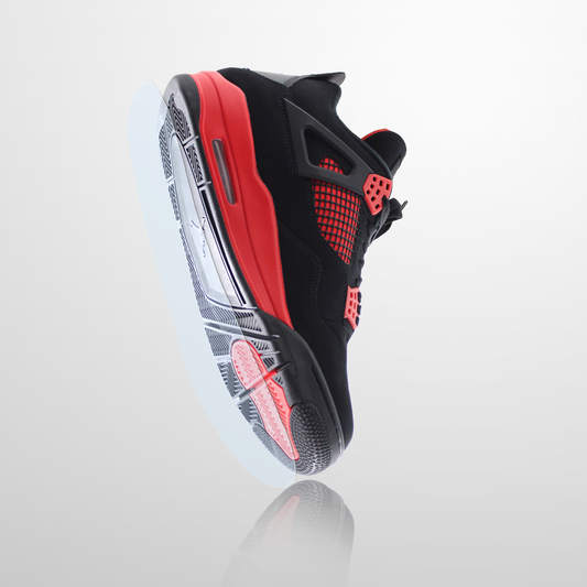 The Jordan 4 Sole Guard is displayed in black and red from a low angle on a light gradient background, emphasizing its distinctive silhouette and durable sole protectors.