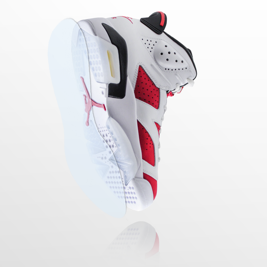 The Jordan 6 Sole Guard's white and red sneaker with black accents is displayed from below at a slight angle on a white background—ideal for highlighting Sole Guard vinyl polymer sole protectors.