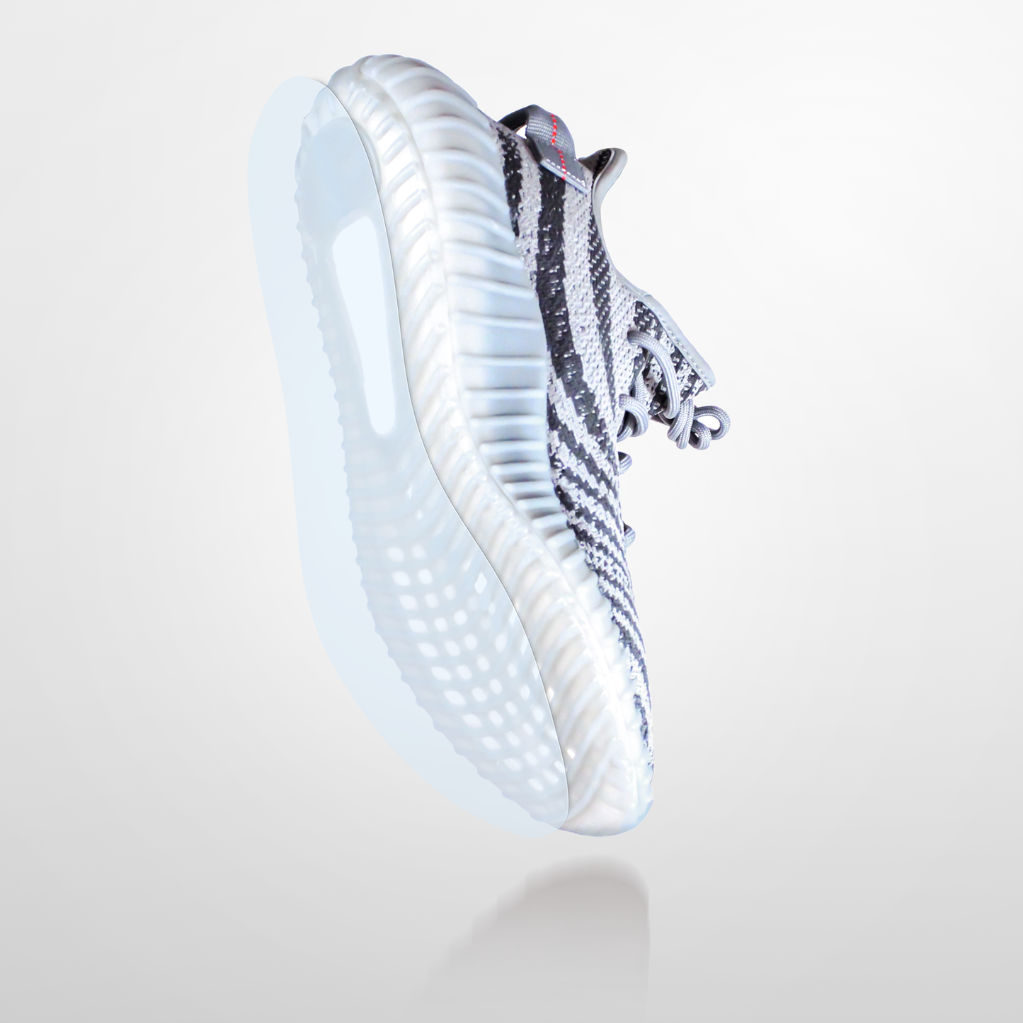 The Yeezy Boost 350 Sole Guard is a black and white athletic sneaker, inspired by the Yeezy Boost 350, with a thick textured sole and added protectors, shown on a light gray background.