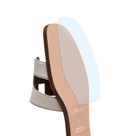 Side view of a Hermès Oran Sandal with a Sole Guard clear blue vinyl polymer sole protector insert, shown on a white background. Product: Sole Guard 3 Pack. Brand: Sole Guard.