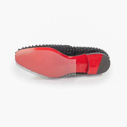 Christian Louboutin Loafers Sole Guard, featuring a striking red bottom and adorned with black spiky studs, rest elegantly on a pristine white background.