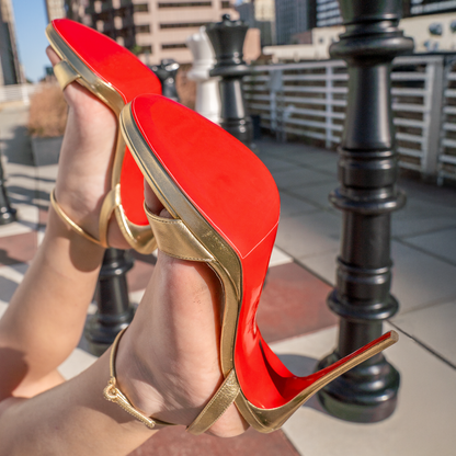 The Christian Louboutin Loubi Queen Sandals Sole Guard 3x Pack features iconic red soles set against giant chess pieces on a rooftop, showcasing how designer footwear is a perfect blend of art and fashion under the open sky.