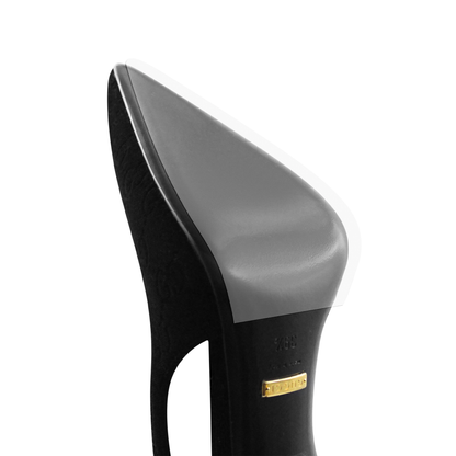 Close-up of a Gucci High Heel Pump Sole Guard, a black high-heeled shoe with a pointed toe, embossed design, and gold Gucci label on the leather sole.