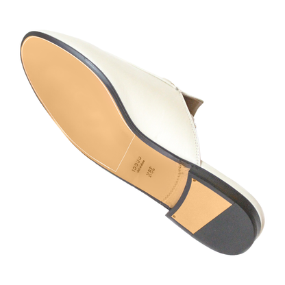 Bottom view of a Gucci Princetown Sole Guard featuring ultra-durable Vinyl Polymer, showcasing a white leather shoe with a tan sole and black heel for enhanced longevity.