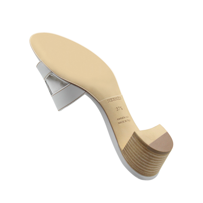 The Hermès Oasis Sandal features a chic white heeled design with a light-colored sole and stacked wooden heel. Use the Hermès Oasis Sandal Sole Guard 3x Pack to protect and preserve its elegance.