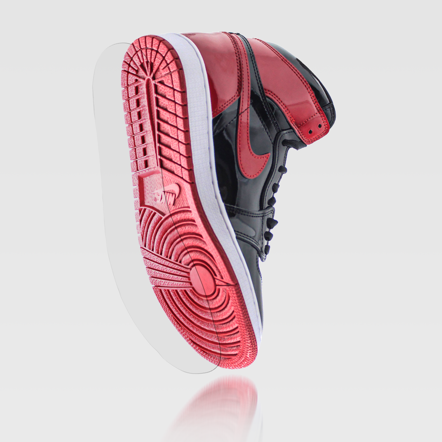 A red and black high-top sneaker with a custom fit levitates, showcasing its sole. The design features a durable vinyl polymer finish and includes the Jordan 1 Sole Guard for style and protection.