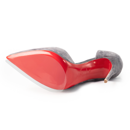 A sleek gray high-heeled shoe flaunts its signature vivid red sole, reminiscent of iconic Christian Louboutin Sole Guard 3 Pack, elegantly placed on its side to highlight the sharp-pointed toe.