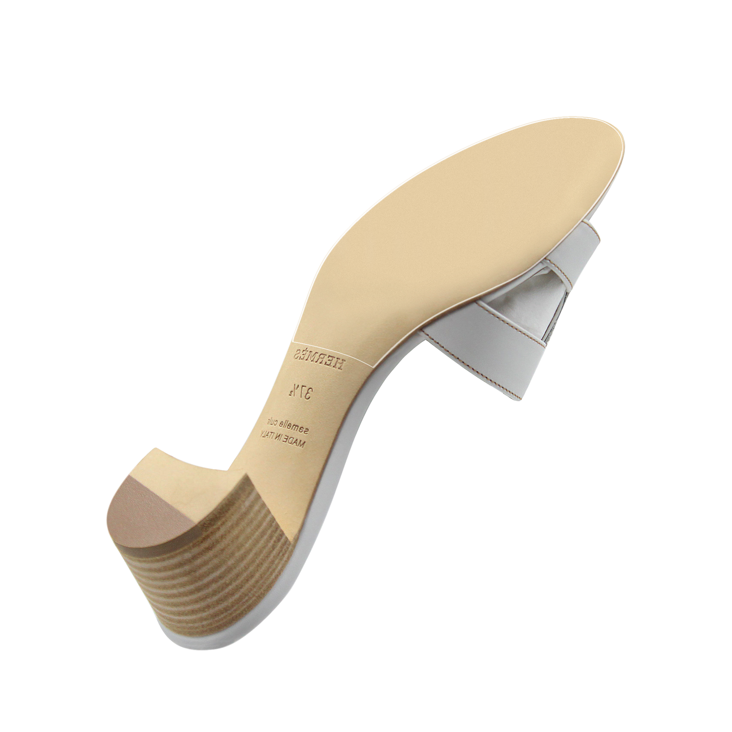 The Hermès Oasis Sandal Sole Guard provides added protection to the low heel ladies' white sandal with a beige sole, viewed from below.