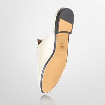 The bottom view shows a white dress shoe with a tan leather sole and heel, featuring the brand imprint. Its elegant design rivals Gucci Princetown mules and boasts ultra-durable vinyl polymer for lasting wear, similar to the Gucci Princetown Sole Guard 3 Pack.