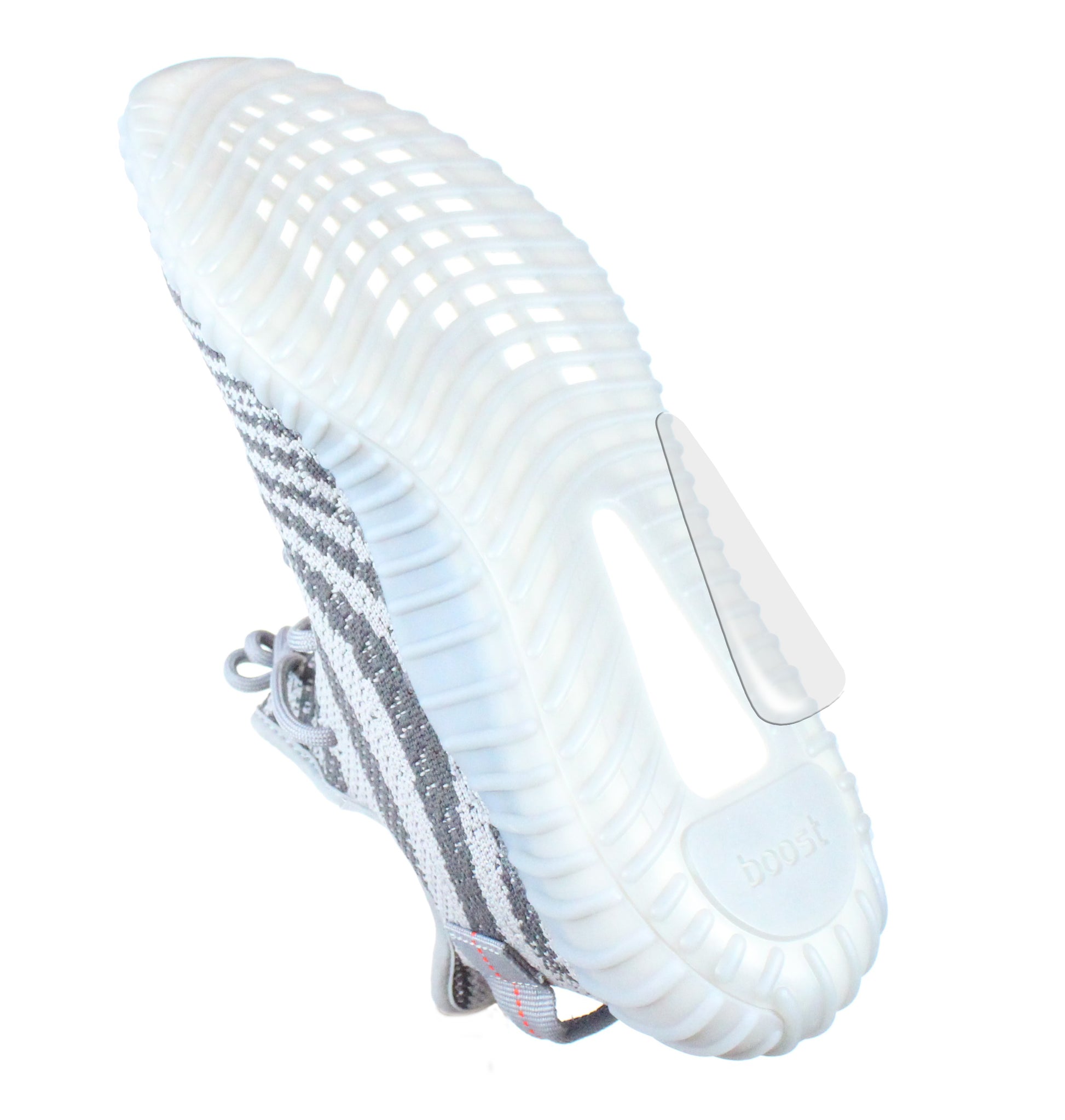 The Adidas Boost Guard sneaker, featuring white and gray stripes and a textured sole, is viewed from an angle that highlights the importance of preserving its design.