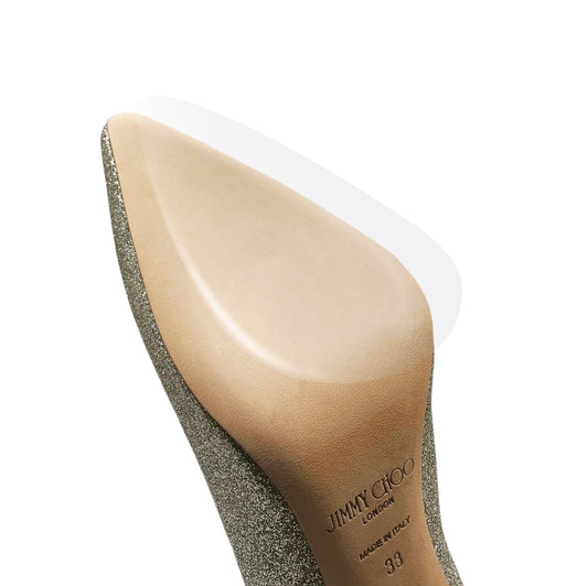 A close-up of a silver glitter high heel with a pointed toe and beige sole, featuring "JIMMY CHOO," enhanced with durable vinyl polymer from the Jimmy Choo Sole Guard 3 Pack for lasting elegance.